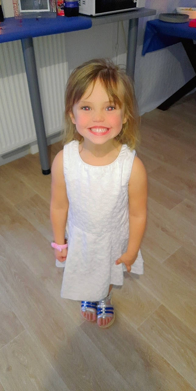 élyana a rejoint le concours — aidez-le/la à gagner de superbes lots ! baby_toddler_clothing, dress, face, facial_expression, floor, flooring, hardwood, head, human_body, iris, joint, joy, knee, neck, person, shoulder, skin, sleeve, smile, toddler