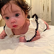 Athena is registered to the contest to win money with this photo: baby, infant, child, face, eyes, hair, clothing, bed, blanket, white, cute, indoors, portrait, curious, soft, furniture, room, skin, person, closeup