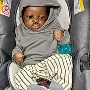 Saadiq joined the competition — help win amazing prizes! baby, car_seat, casual_wear, child, clenched_fist, cute, dark_skin, expression, gray_clothing, hoodie, indoor, infant, pacifier, portrait, seatbelt, seated, socks, striped_pants, warning_label, young_child