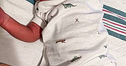 Saadiq joined the competition — help win amazing prizes! arm, baby, babywear, blanket, child, clothing, cute, dinosaur_print, human, indoors, infant, leg, newborn, onesie, patterned, portrait, resting, skin, sleeping, toddler