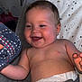 baby, baby_seat, chubby_cheeks, clothing, cushion, cute, diaper, fabric, face, grey, hand, happy, indoor, infant, joy, pattern, person, polka_dot, skin, smiling