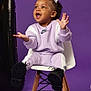 Ariella is registered to the contest to win money with this photo: toddler, child, smiling, purple_background, nike, tracksuit, sneakers, curly_hair, bows, white_chair, wooden_legs, happy, studio_photo, indoor, clothing, footwear, expressive, cute, seated, portrait
