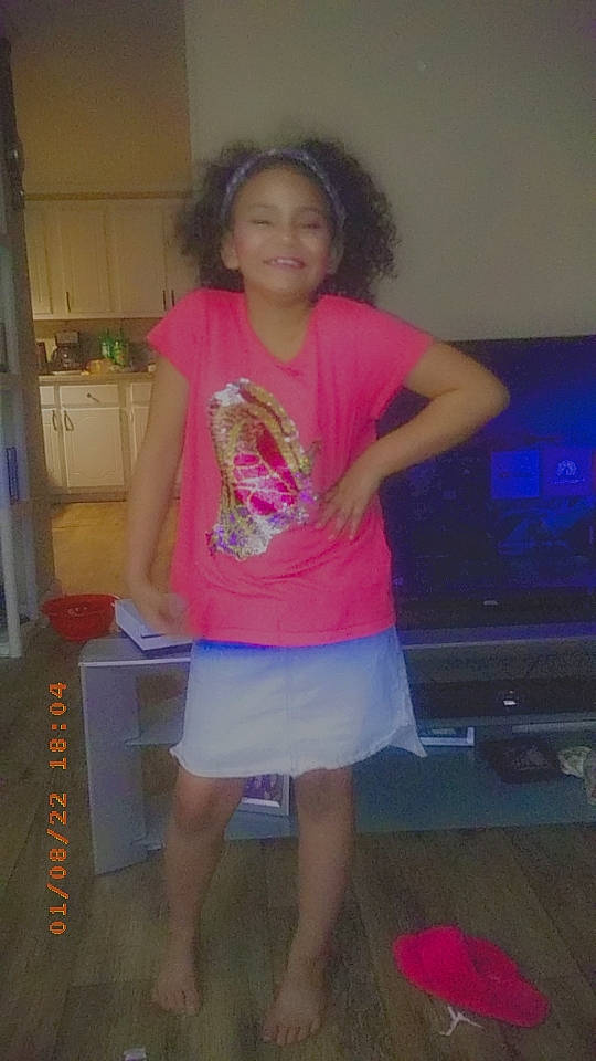 Kamille is registered to the contest to win money with this photo: entertainment, event, flooring, fun, human_leg, joint, joy, knee, leg, leisure, long_hair, magenta, person, pink, shorts, shoulder, smile, standing, t_shirt, television