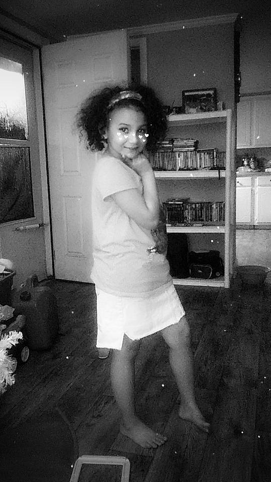 Kamille is registered to the contest to win money with this photo: black, black_and_white, bookcase, child, door, flash_photography, flooring, fun, hairstyle, human_leg, joy, monochrome, monochrome_photography, person, room, shelf, shelving, smile, standing, style