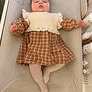 Joséphine participe au concours pour gagner de l'argent avec cette photo : baby, baby_care_products, baby_girl, changing_mat, child, clothing, cute, expression, face, foot, hand, indoors, infant, knitted_vest, lying_down, padded_surface, plaid_dress, skin, soft_lighting, tights