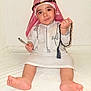 Mikael joined the competition — help win amazing prizes! child, toddler, traditional_clothing, headwear, prayer_beads, white_background, barefoot, sitting, curious_expression, indoors, handheld_object, young_child, cultural, portrait, innocence, soft_surface, cute, person, closeup, smile