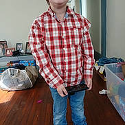 Tyler Jr. joined the competition — help win amazing prizes! child, boy, smile, plaid_shirt, jeans, tablet, indoor, wooden_floor, shoes, photographs, toys, plastic_container, clutter, casual_clothing, home, person, portrait, happy, standing, technology