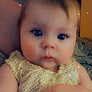 Olivia is registered to the contest to win money with this photo: baby, infant, child, face, eyes, hand, polka_dot, dress, sparkles, filter, close_up, skin, cute, adorable, person, indoor, portrait, holding, young, soft_lighting
