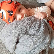 Noah joined the competition — help win amazing prizes! baby, child, pacifier, blanket, orange_hat, halloween_theme, carpet, floor, smiling, cute, infant, clothing, indoor, playful, hand, headwear, costume, pumpkin_pattern, person, face
