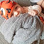 baby, child, pacifier, blanket, orange_hat, halloween_theme, carpet, floor, smiling, cute, infant, clothing, indoor, playful, hand, headwear, costume, pumpkin_pattern, person, face