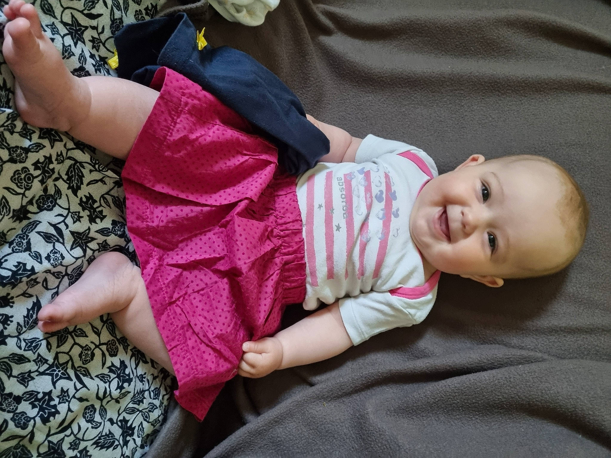 Anaële a rejoint le concours — aidez-le/la à gagner de superbes lots ! baby, baby_toddler_clothing, cheek, child, comfort, foot, grass, happy, human_leg, joy, magenta, nail, pattern, person, pink, sitting, skin, sleeve, smile, sock