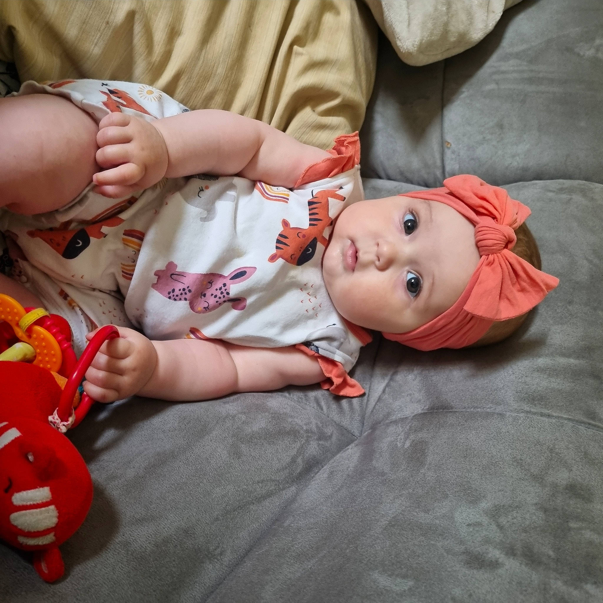 Anaële participe au concours pour gagner de l'argent avec cette photo : baby, baby_toddler_clothing, cheek, comfort, eye, face, facial_expression, flooring, head, headwear, human_body, leg, lip, mouth, nose, orange, person, skin, toddler, toy