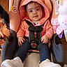 baby, car_seat, casual, child, clothing, cute, flooring, happy, hoodie, indoor, infant, person, pink, portrait, seat, smiling, straps, toy, white_sneakers, young_child