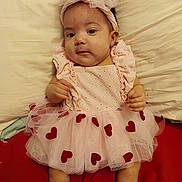 Aidalenyz is registered to the contest to win money with this photo: baby, child, clothing, cream, cute, cute_outfit, dress, face, headband, hearts, indoor, infant, lying_down, person, pink, portrait, red, socks, soft_toys, tutu