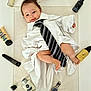 baby, infant, tie, striped_tie, white_shirt, towel, watch, cologne, perfume_bottle, skincare_tube, jar, electric_trimmer, clipper_attachment, foot, legs, smile, portrait, props, flat_lay, grooming_products