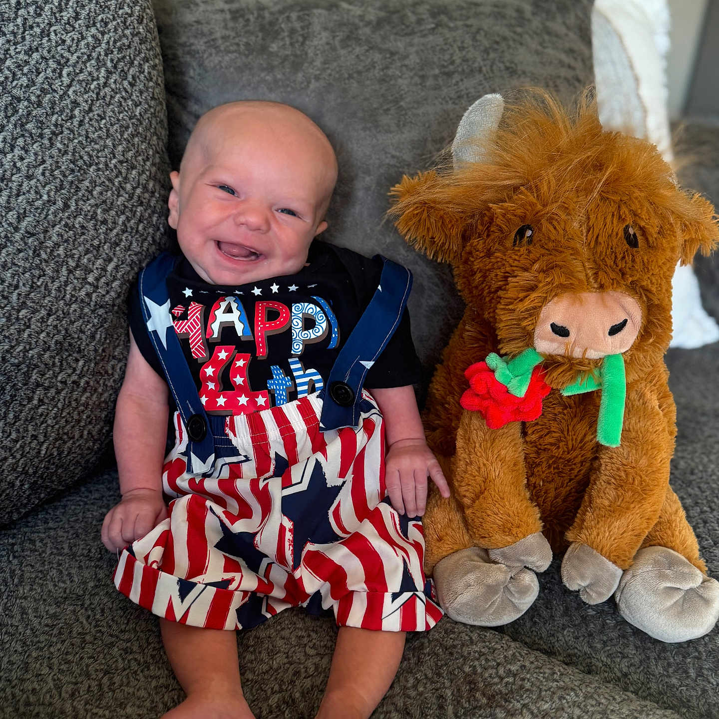 Braxton is registered to the contest to win money with this photo: baby, child, clothing, comfort, couch, cute, decor, fabric, funny, gray_couch, happy, indoors, infant, plush_toy, portrait, sitting, smiling, soft_toy, stuffed_animal, toy