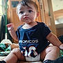 baby, child, infant, drool, pout, broncos_shirt, diaper, sitting, bed, blanket, indoor, furniture, wooden_cabinet, cute, soft_light, person, portrait, socks, home, young