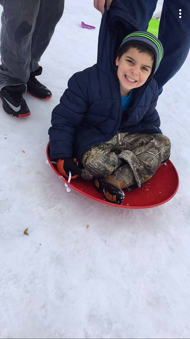 Braden is registered to the contest to win money with this photo: ice, joy, person, recreation, sled, sledding, snow, vehicle, winter, winter_sport