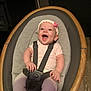Genesis is registered to the contest to win money with this photo: baby, smile, headband, pink, rocker, seat, straps, cushion, indoor, wood_floor, happy, infant, clothing, person, child, face, hands, legs, sitting, cute