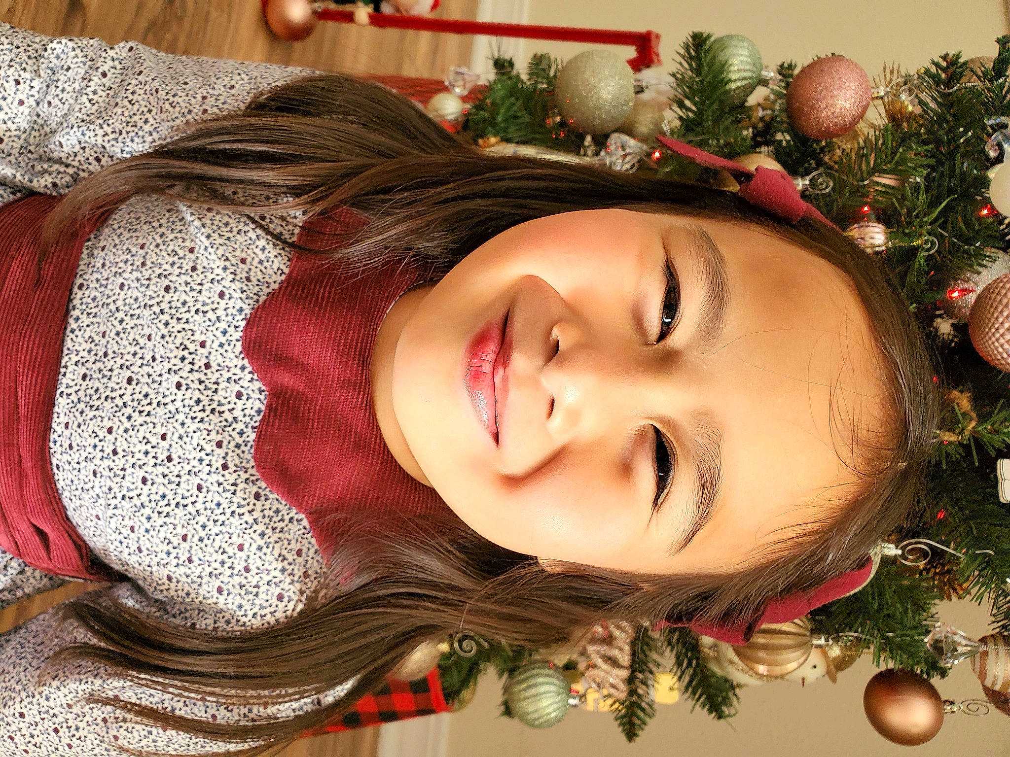 Clary is registered to the contest to win money with this photo: bangs, brown_hair, christmas, christmas_decoration, christmas_ornament, christmas_tree, event, eyelash, facial_expression, happy, head, holiday, holiday_ornament, human_body, joy, ornament, person, plant, red, smile