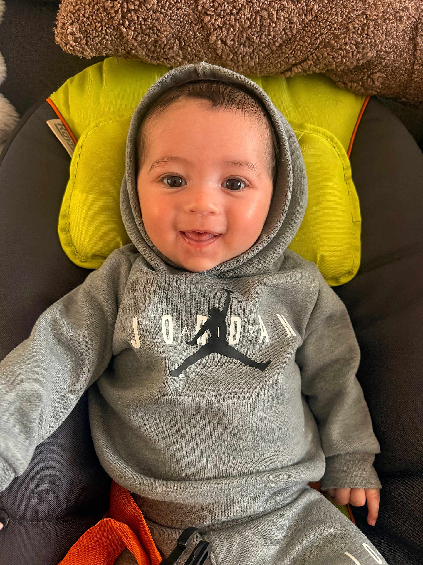 Ayden a rejoint le concours — aidez-le/la à gagner de superbes lots ! baby, infant, child, smiling, hoodie, sweatshirt, jordan_logo, car_seat, cushion, pillow, blanket, happy, brown_blanket, eyes, face, portrait, indoor, safety_strap, hands, clothing