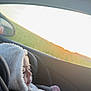 child, toddler, car_seat, car_interior, window, sunset, blanket, hooded_jacket, seatbelt, profile, side_view, side_mirror, cozy, portrait, travel, road_trip, dusk, sleepy, eyelashes, soft_texture