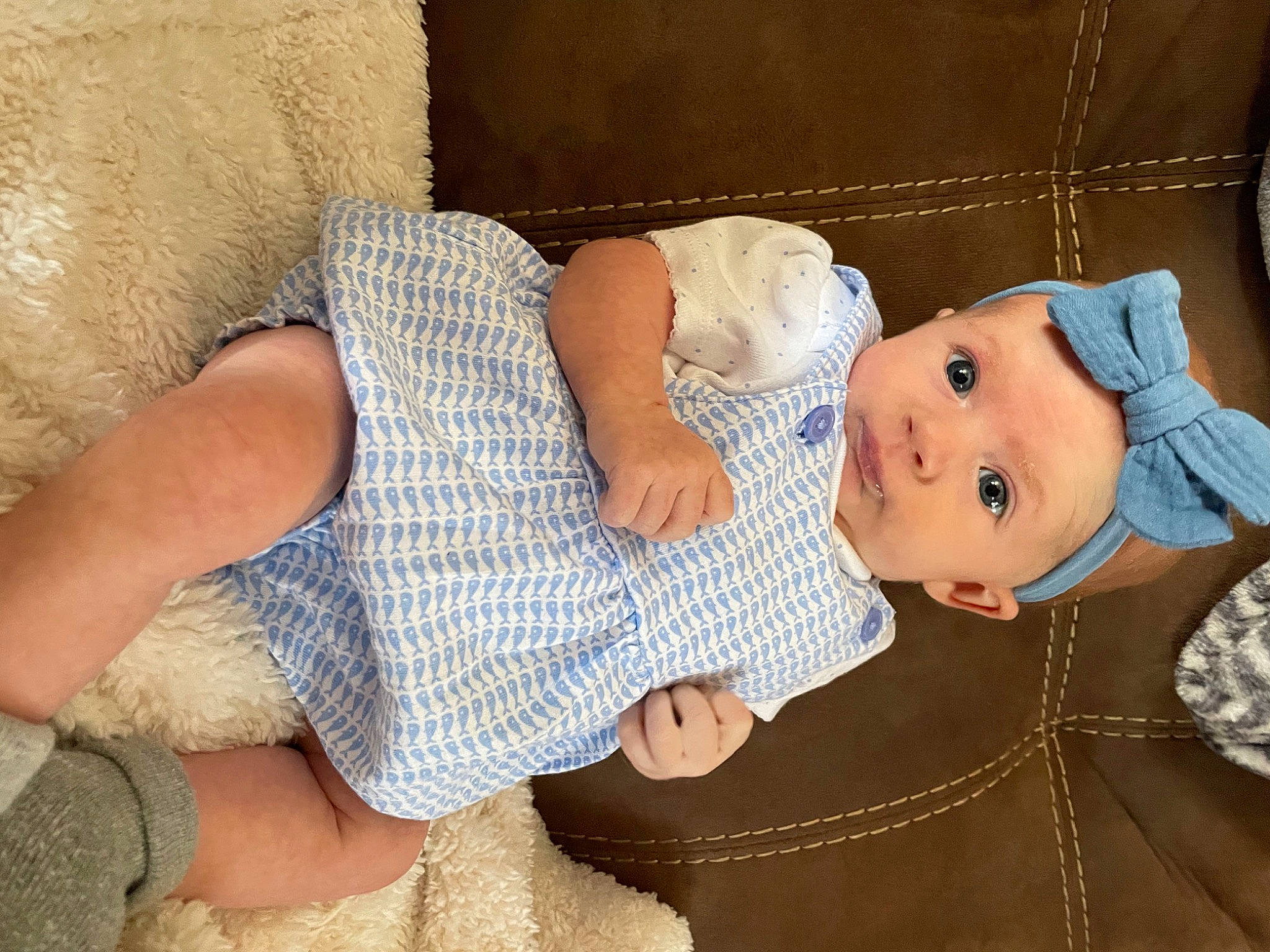 Kinzley is registered to the contest to win money with this photo: baby, baby_products, baby_toddler_clothing, cheek, child, comfort, dress, fashion_accessory, foot, headgear, human_leg, lap, linens, pattern, person, sitting, skin, sleeve, smile, thigh