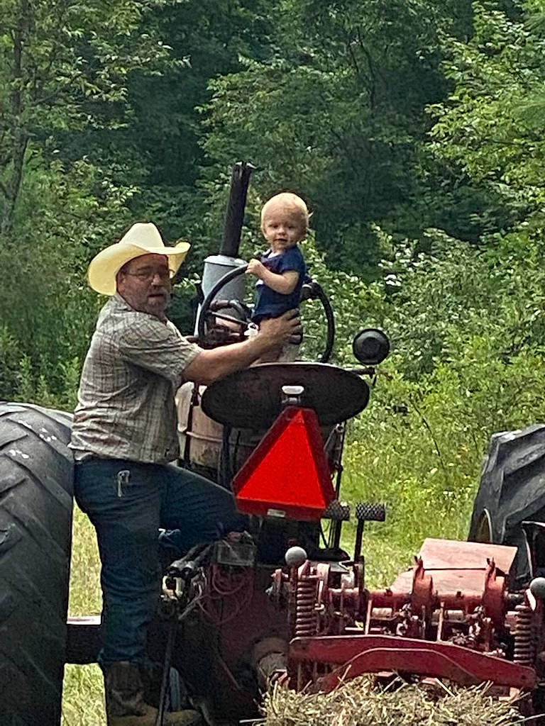 Gabe is registered to the contest to win money with this photo: auto_part, automotive_exterior, automotive_tire, automotive_wheel_system, fedora, forest, grass, hat, headwear, motor_vehicle, musician, person, plant, recreation, soil, sun_hat, tire, tread, tree, vehicle