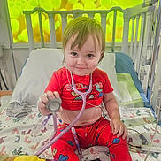 Jase joined the competition — help win amazing prizes! toddler, child, hospital_bed, stethoscope, pajamas, dog, medical_equipment, smile, toy, bed, blanket, hospital, playful, medical_tubes, person, indoor, cute, colorful, animal, patient