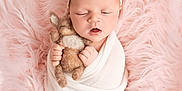 Aurora is registered to the contest to win money with this photo: newborn, baby, sleeping, wrapped, blanket, stuffed_animal, bunny, soft_texture, pink, headband, peaceful, cute, infant, portrait, closeup, cozy, child, toddler, hands, face