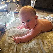 Rylee is registered to the contest to win money with this photo: baby, infant, diaper, blanket, plush_toy, play_gym, sun_toy, soft_toy, indoor, child, cute, curious, lying_down, person, skin, head, arm, floor, home, light