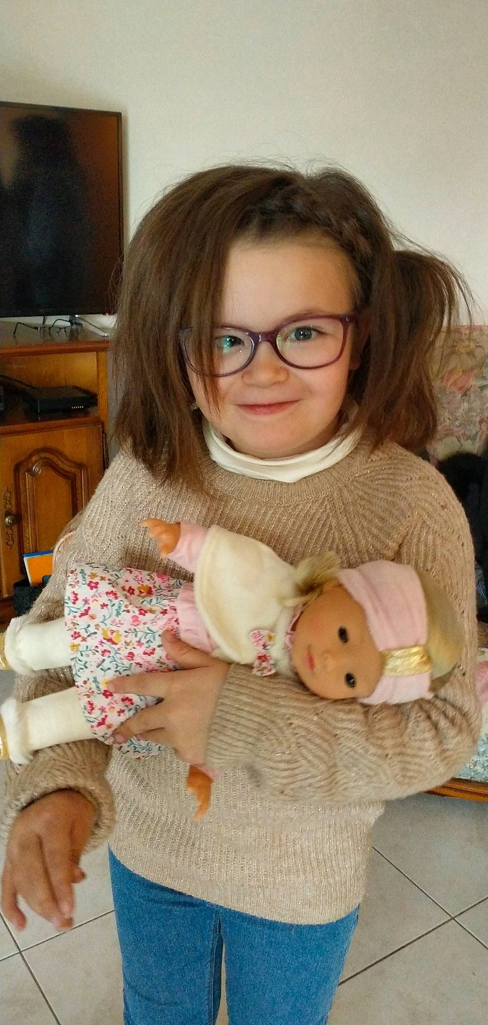 Lou-anne a rejoint le concours — aidez-le/la à gagner de superbes lots ! baby_toddler_clothing, blond, cheek, child, comfort, eyewear, face, facial_expression, fawn, finger, glasses, joy, lap, nose, person, sitting, skin, smile, television, toy