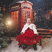 Evie-Rose joined the competition — help win amazing prizes! bench, boots, child, christmas_tree, decoration, festive, girl, happy, holiday, lamp_post, night, outdoor, portrait, red_dress, smile, snow, snowfall, telephone_booth, white_jacket, winter