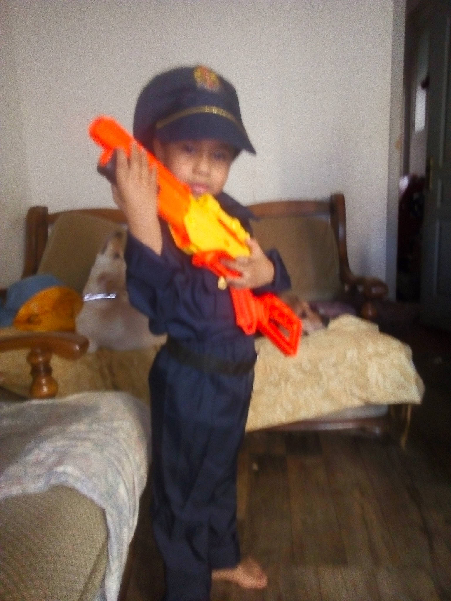 Mathias participe au concours pour gagner de l'argent avec cette photo : cap, child, comfort, door, flooring, fun, hardwood, hat, headwear, musical_instrument, person, recreation, room, sitting, string_instrument, sun_hat, table, toddler, varnish, wind_instrument