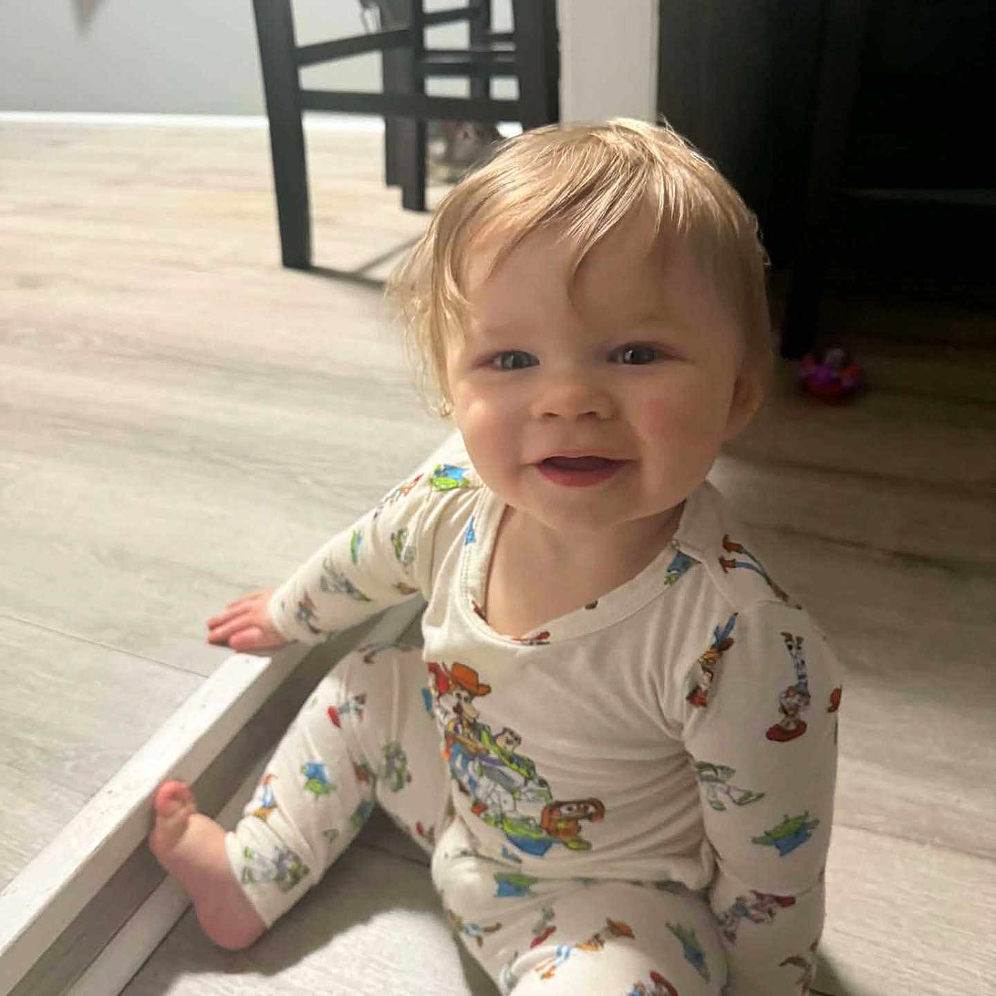 Wyatt joined the competition — help win amazing prizes! baby, child, toddler, sitting, smiling, portrait, indoors, home, pajamas, printed_clothing, blond_hair, blue_eyes, barefoot, floor, furniture, mirror, television, toy, natural_light, happy