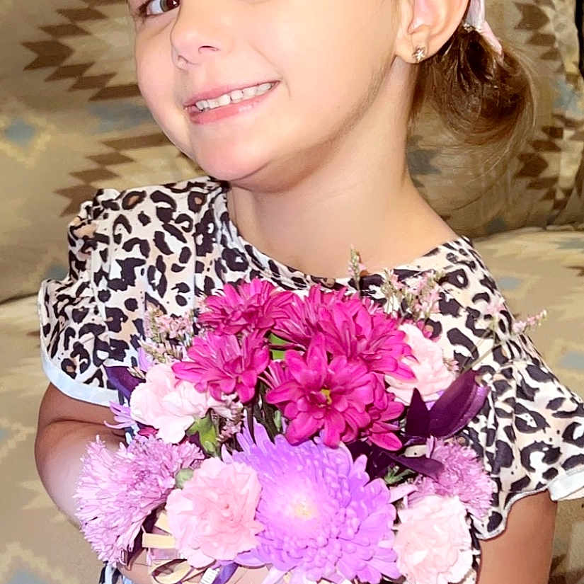 Sylvia is registered to the contest to win money with this photo: blouse, child, clothing, daisy, face, female, flower, flowerarrangement, flowerbouquet, girl, head, jeans, pants, person, petal, photography, plant, portrait, pottedplant, purple