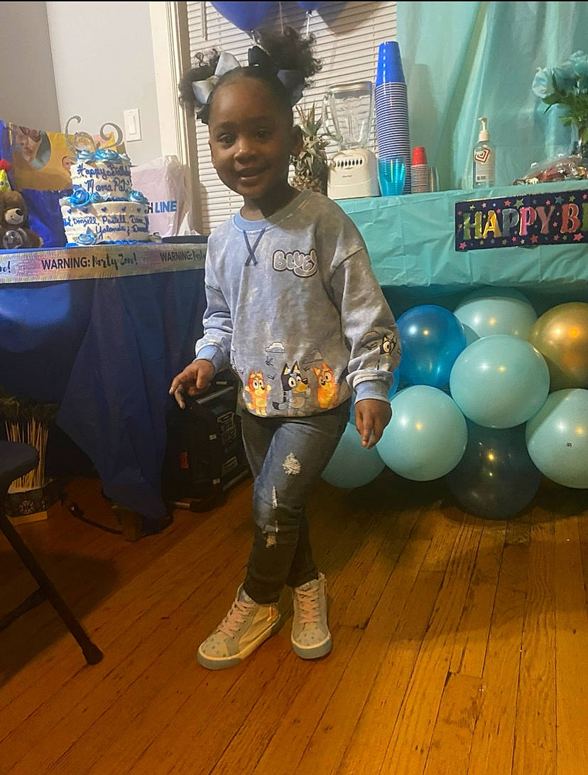 Taylor is registered to the contest to win money with this photo: balloon, blue, chair, child, electric_blue, event, eyewear, fashion_design, flooring, fun, hair, happy, joy, leisure, person, play, sandal, sitting, smile, t_shirt