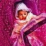 baby, child, stroller, hooded_clothing, pink, blanket, infant, face, portrait, wrapped, warm, cute, outdoor, seat, young, person, bundle, fabric, texture, curious