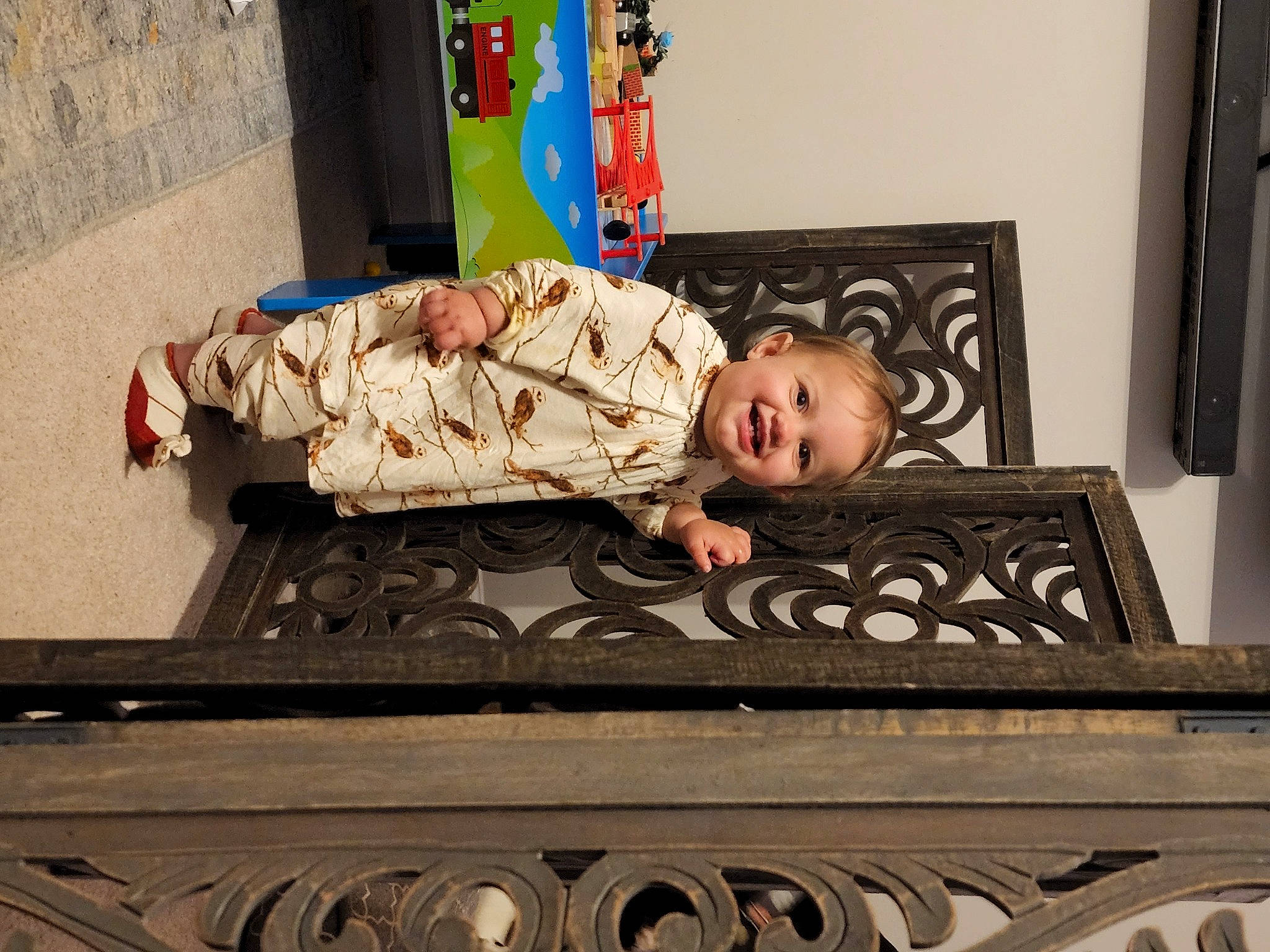 Madeline is registered to the contest to win money with this photo: baby, child, comfort, flooring, handrail, joy, metal, pattern, person, rectangle, room, sitting, smile, toddler, wood