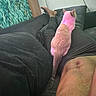 Beyonce is registered to the contest to win money with this photo: animal, bare_chest, blanket, casual, cat, comfort, couch, foot, furniture, home, indoor, legs, living_room, person, pet, relaxing, resting, screen, television, wall