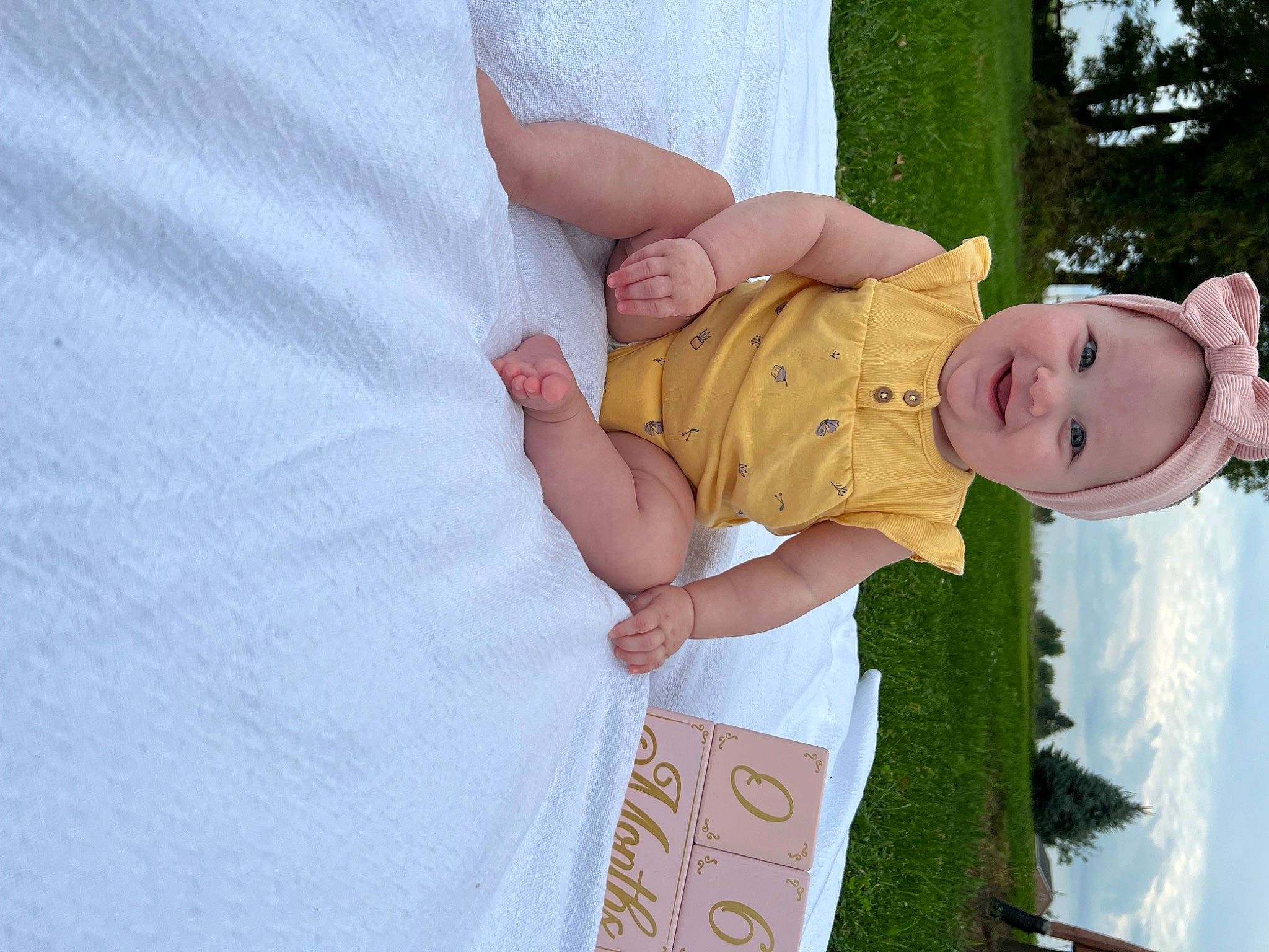Remington is registered to the contest to win money with this photo: baby, baby_products, baby_toddler_clothing, child, event, foot, fun, gesture, grass, happy, hat, joy, nail, pattern, people_in_nature, person, plant, sleeve, smile, thumb