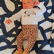 Maëllya participe au concours pour gagner de l'argent avec cette photo : baby, infant, headband, baby_clothes, patterned_pants, footwear, blanket, abstract_pattern, lying_down, smiling, cute, face, person, child, indoors, cozy, fashion, apparel, portrait, soft_lighting