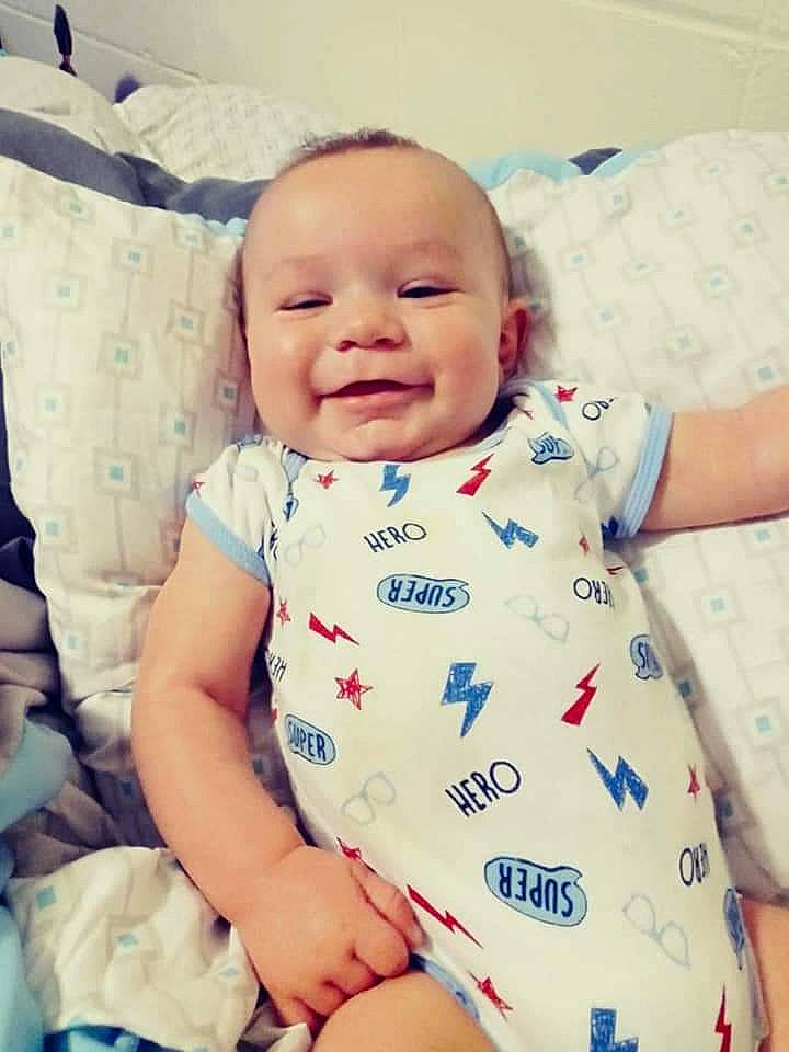 Rayden is registered to the contest to win money with this photo: baby, baby_toddler_clothing, cheek, collar, comfort, face, facial_expression, happy, iris, linens, lip, mouth, person, product, skin, sleeve, smile, t_shirt, textile, toddler