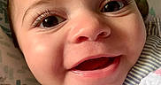 Isabella is registered to the contest to win money with this photo: baby, blanket, cheeks, child, close_up, clothing, cute, expression, eyes, face, happy, infant, joy, mouth, person, portrait, skin, smile, striped, young