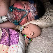 Snow Angel joined the competition — help win amazing prizes! person, baby_doll, sleeping, pacifier, cpap_mask, quilt, pillow, bed, bead_necklace, earring, close_up, indoor, blanket, resting, face, human, medical_device, comfort, intimacy, nighttime