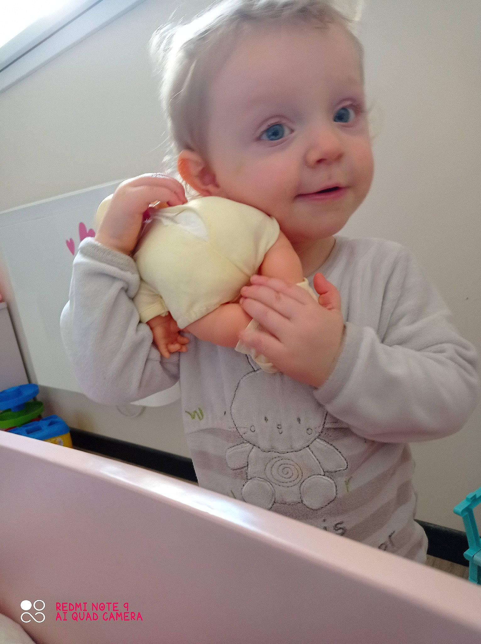 Hope participe au concours pour gagner de l'argent avec cette photo : arm, baby, baby_safety, baby_toddler_clothing, cheek, child, face, finger, gesture, hand, happy, nail, person, pink, room, skin, sleeve, smile, standing, thumb