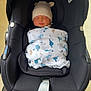 baby, newborn, car_seat, blanket, hat, sleeping, infant, child, indoor, black, fabric, wheel, floor, cute, bundle, resting, toddler, comfort, soft, transport
