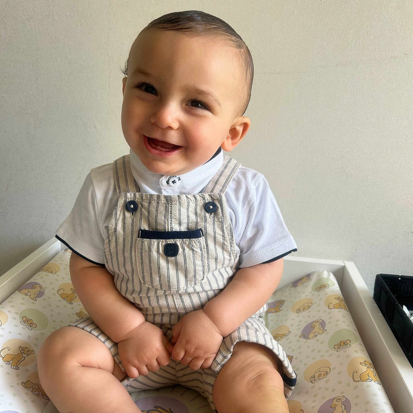 Ahmed a rejoint le concours — aidez-le/la à gagner de superbes lots ! baby, smiling, child, infant, sitting, overalls, white_shirt, cute, happy, indoor, changing_pad, cartoon, lion_cub, patterned, skin, face, hair, hands, legs, foot