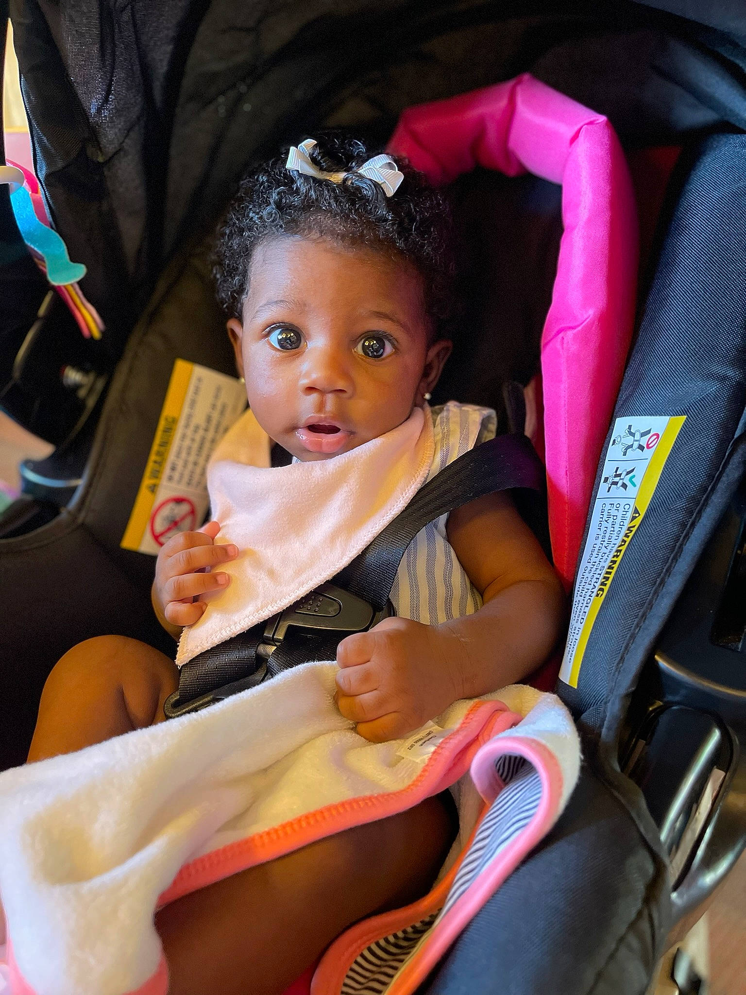 Kali is registered to the contest to win money with this photo: baby, baby_carriage, baby_products, black_hair, chair, child, comfort, event, fun, happy, human_leg, lap, leisure, magenta, person, pink, recreation, sitting, skin, thigh