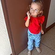 Cataleya participe au concours pour gagner de l'argent avec cette photo : toddler, child, girl, red_shirt, blue_jeans, hair_bow, standing, brown_door, floor, sandals, curly_hair, casual_clothing, indoor, portrait, cute, pensive, young_child, fashion, person, full_body